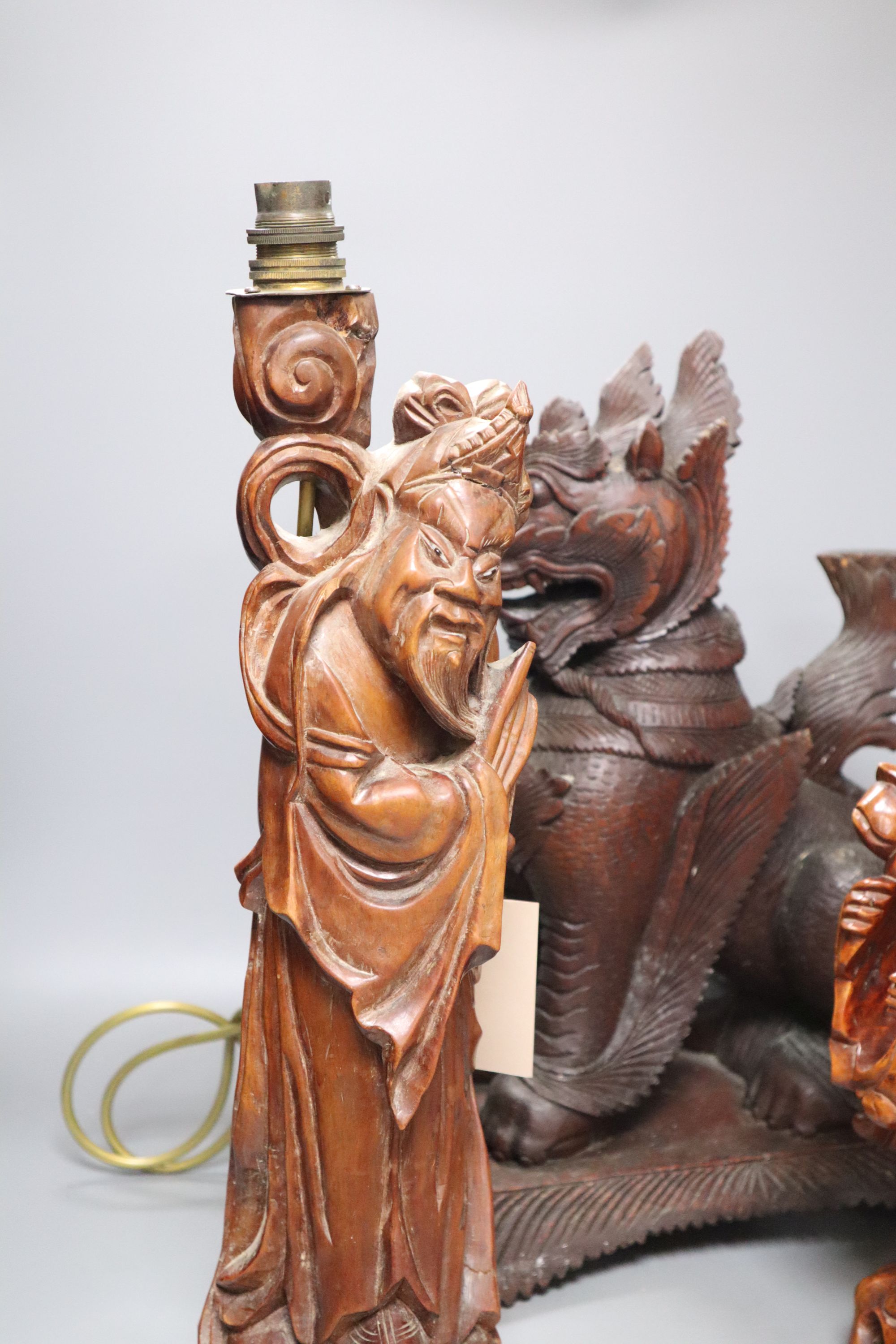 An Indonesian large carved wood model of a seated kylin, on plinth base and two Chinese rootwood carvings of elders, H approx 44cm (kyl